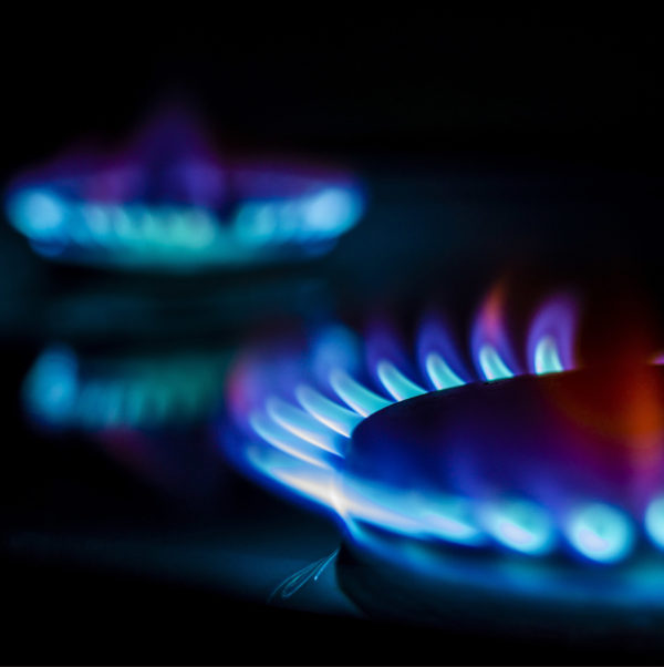 On a gas burner with a burning fire on a black background, the front and back background is blurred