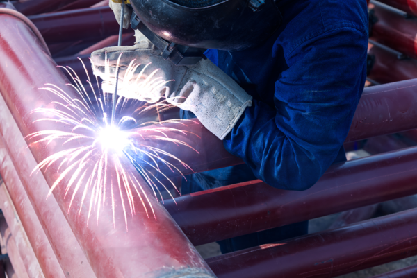 Hot Work Safety Training - Metal work over some metal pipes with sparks coming out