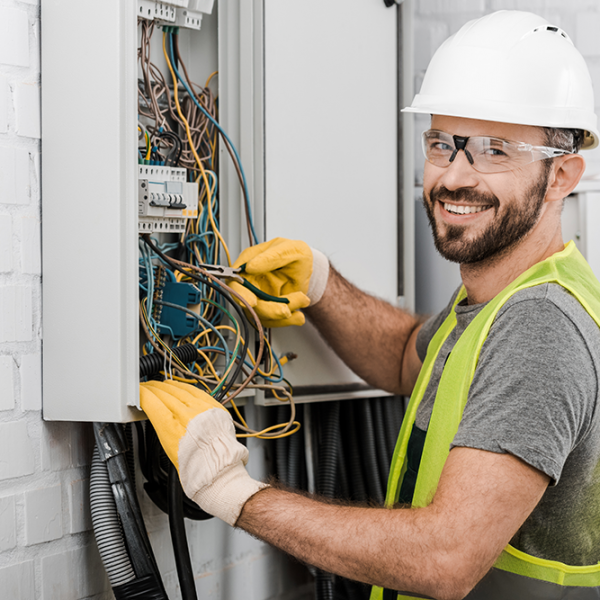 Electrician working on wires in a fuse box